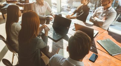 A team of young businessmen working and communicating together in an office. Corporate businessteam and manager in a meeting